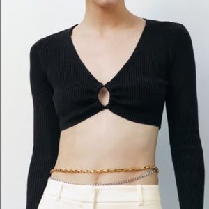 Cropped top with V-neckline with ruched drawstring opening. Long sleeves.